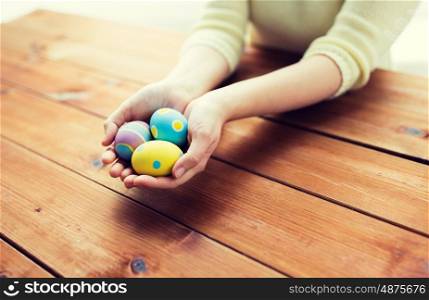 easter, holidays, tradition and people concept - close up of woman hands holding colored easter eggs. close up of woman hands with colored easter eggs