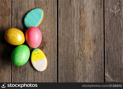 Easter homemade gingerbread cookie and eggs over wooden table