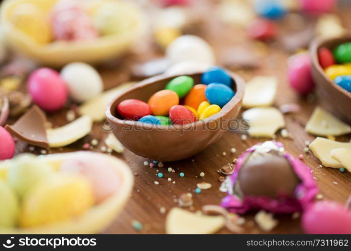 easter, junk-food, confectionery and unhealthy eating concept - close up of chocolate eggs and candy drops on table. chocolate easter eggs and candy drops on table