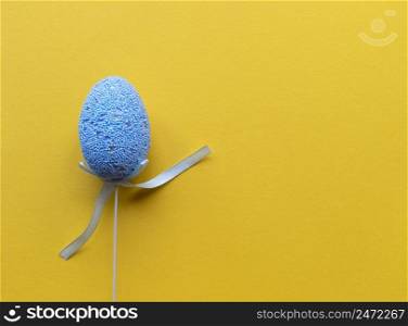 Easter minimalistic ban≠r with©space. Flat lay with©space. Sing≤blue egg yellow background.. Easter minimalistic ban≠r with©space. Flat lay with©space. Sing≤blue egg yellow background. Stock photo.