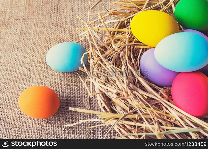 easter painted eggs in basket on fabric background