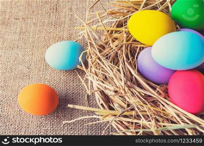 easter painted eggs in basket on fabric background