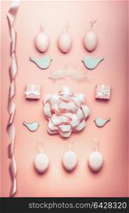 Easter pastel pink composing with eggs,ribbon,bow, birds and feather on table background, top view, flat lay