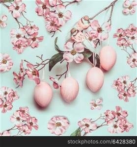 Easter pastel pink pattern with hanged eggs and decor blossom on turquoise background