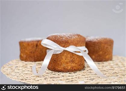 Easter pastries, sponge cake with a white bow is on a napkin. Place for text. Sponge cake with a white bow is on a napkin