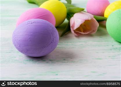 Easter purple egg and pink tulip . Easter background with vibrant purple painted eggs and pink tulip. Happy Easter greeting card.