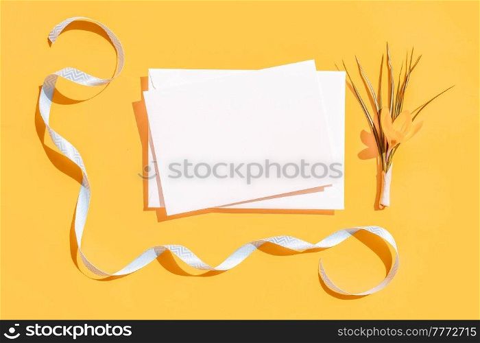 Easter scene with crocus flower over illuminating yellow background, frame with copy space over white paper note. Easter scene with white eggs