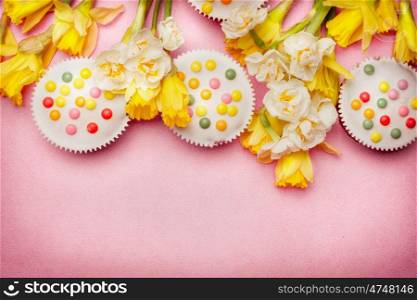 Easter setting with daffodils flowers and cakes , top view, border