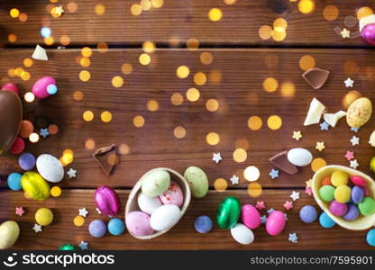 easter, sweets and confectionery concept - chocolate eggs and candy drops on wooden background. chocolate eggs and candy drops on wooden table