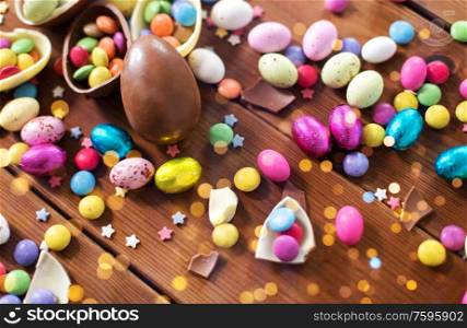 easter, sweets and confectionery concept - close up of chocolate eggs and candy drops on wooden table. chocolate eggs and candy drops on wooden table