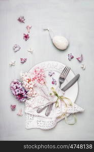 Easter table place setting with decor egg, plate, cutlery, napkin, ribbon and beautiful pastel pale hyacinths flowers, top view composing