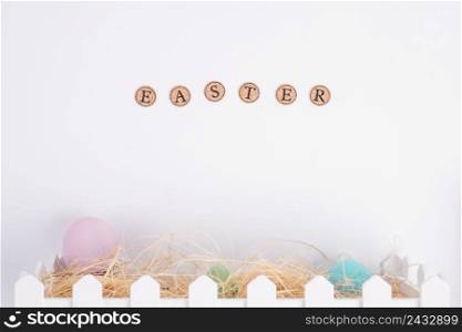 easter word near bright eggs hay box