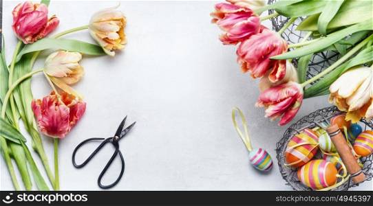 Easter workspace with colorful tulips, shears and deco eggs in basket, top view, frame