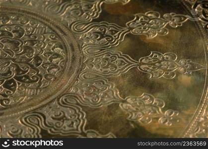 Eastern engraving on bronze, close-up. Oriental patterns on metal