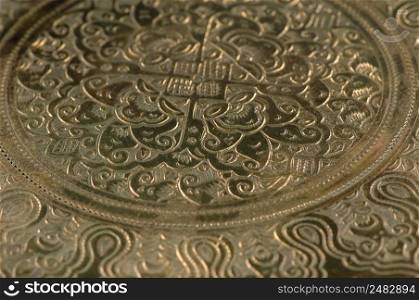 Eastern engraving on bronze, close-up. Oriental patterns on metal