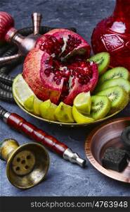 Eastern smoking hookah and dish with kiwi,pomegranate and lime