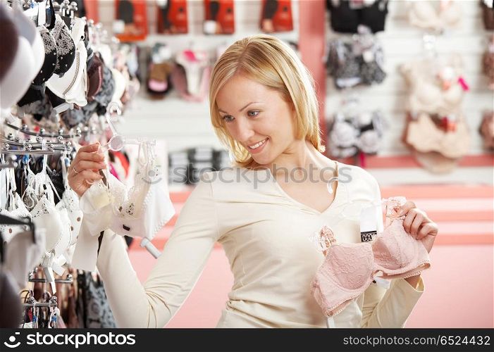 Easy choice. The blonde chooses a brassiere in shop