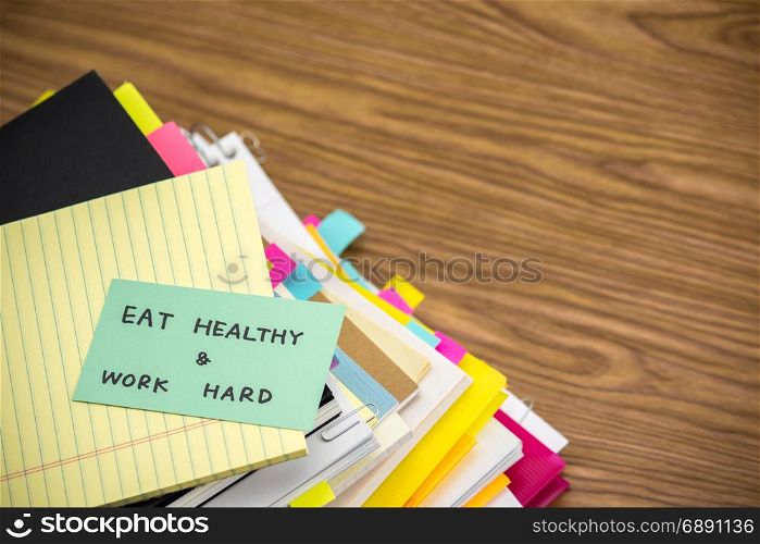 Eat Healthy Work Hard; The Pile of Business Documents on the Desk