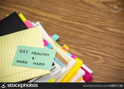 Eat Healthy Work Hard; The Pile of Business Documents on the Desk