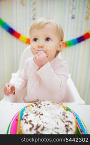 Eat smeared baby eating birthday cake