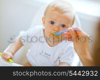 Eat smeared pretty baby girl eating from spoon&#xA;