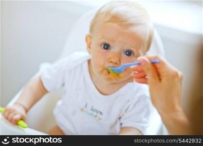 Eat smeared pretty baby girl eating from spoon&#xA;