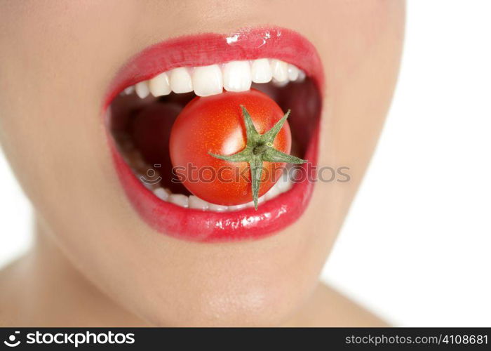 Eating a red tomato macro of woman teeth and red lips mouth