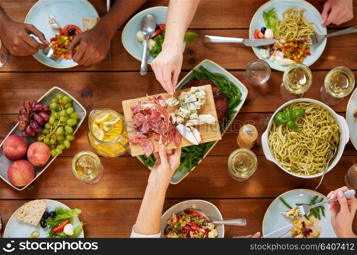 eating and leisure concept - group of people having dinner at table with food. group of people eating at table with food