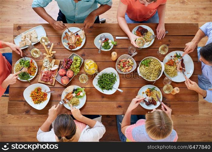 eating and leisure concept - group of people having dinner at table with food. group of people eating at table with food. group of people eating at table with food