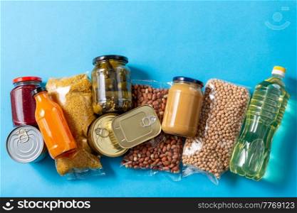 eating, charity and donation concept - close up of different packed food on blue background. close up of packed food on blue background