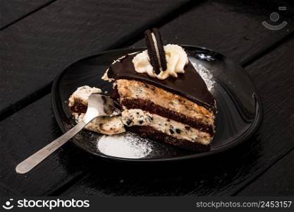 Eating creamy cheesecake with chocolate cookies and cream biscuits.
