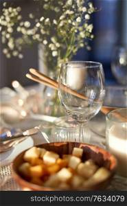eating, holiday and celebration concept - empty wine glass on served dinner party table at home. wine glass on served dinner party table at home