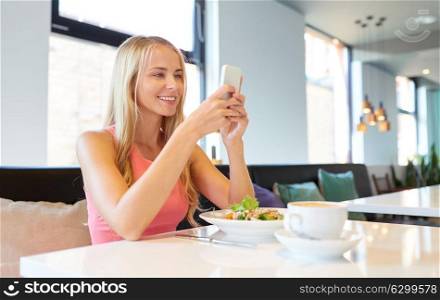 eating, technology, communication and leisure concept - happy woman with smartphone, salad and coffee for lunch at restaurant. happy woman with smartphone eating at restaurant