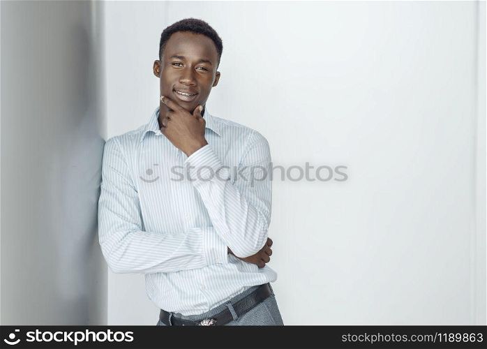 Ebony businessman poses in office building. Successful business person, black man in formal wear, shopping center