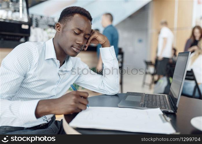 Ebony businessman working on laptop in office. Successful business person at his workplace, black man in formal wear
