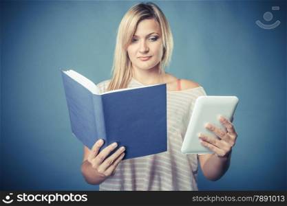 Ebook vs book. Young woman using tablet computer reading. Female with traditional book and e-book reader touchpad pc blue background. Vintage filter