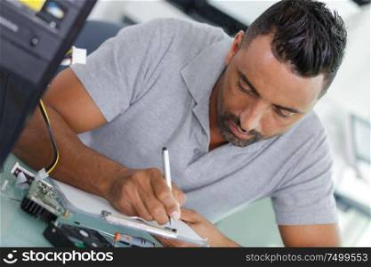 echnician writing a list of things to repair computer