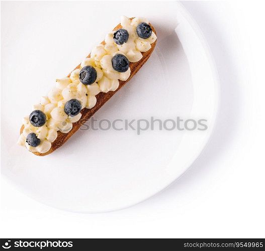 Eclair with vanilla cream and blueberries