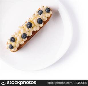 Eclair with vanilla cream and blueberries