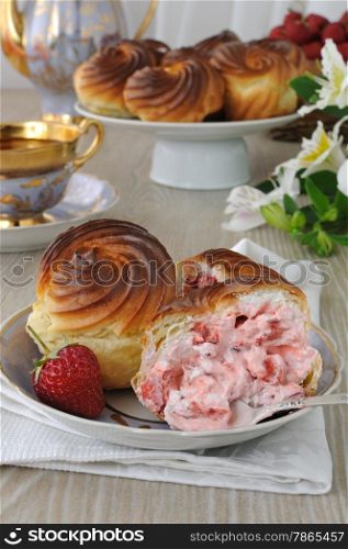 Eclairs with cream filling and slices of fresh strawberries