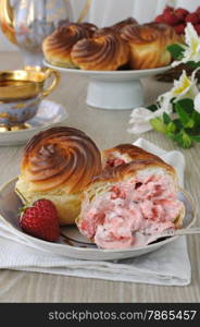 Eclairs with cream filling and slices of fresh strawberries