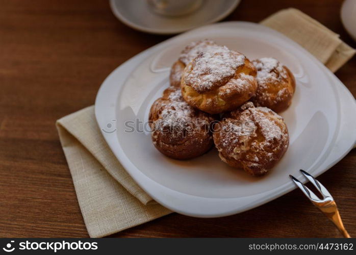 eclairs with custard cream with tea and teapot