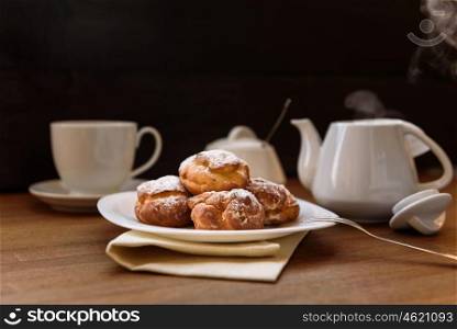 eclairs with custard cream with tea and teapot