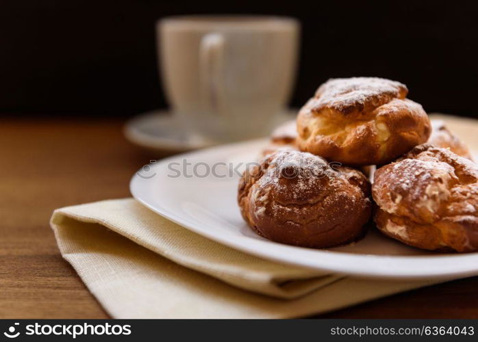 eclairs with custard cream with tea and teapot