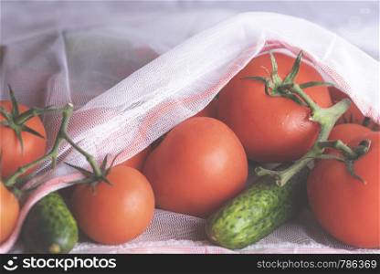 Eco bag with fresh vegetables, tomatoes, and cucumbers. Groceries in a reusable bag