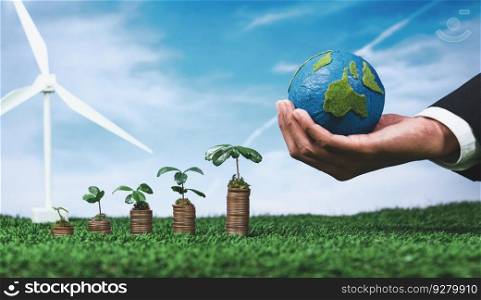 Eco business invest on environment conservation subsidize, coin stack with grow seedling, hand holding paper Earth and wind turbine. Sustainable financial growth with clean and renewable energy. Alter. Eco business investment or environment conservation with coin stack. Alter