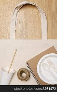 Eco friendly concept, Eco bag with notebook food container and jute rope on wooden background.