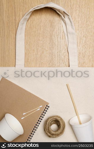 Eco friendly concept, Eco bag with notebook paper cup and jute rope on wooden background.