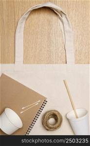 Eco friendly concept, Eco bag with notebook paper cup and jute rope on wooden background.