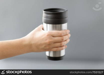 eco friendly concept - hand holding hot drink in tumbler mug or thermo cup. hand holding tumbler mug or thermo cup